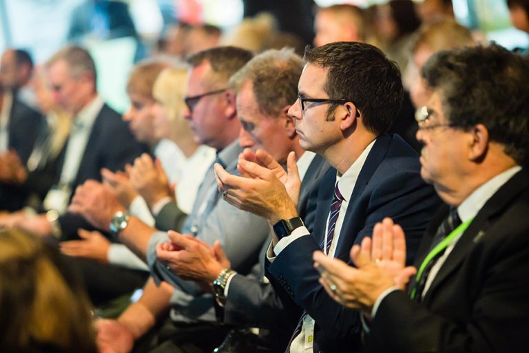 Colin Bamford and other attendee's applaud a speaker