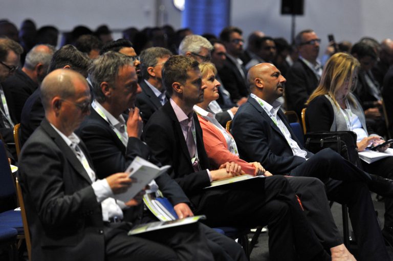 Attendee's at the conference sit and watch the first panel