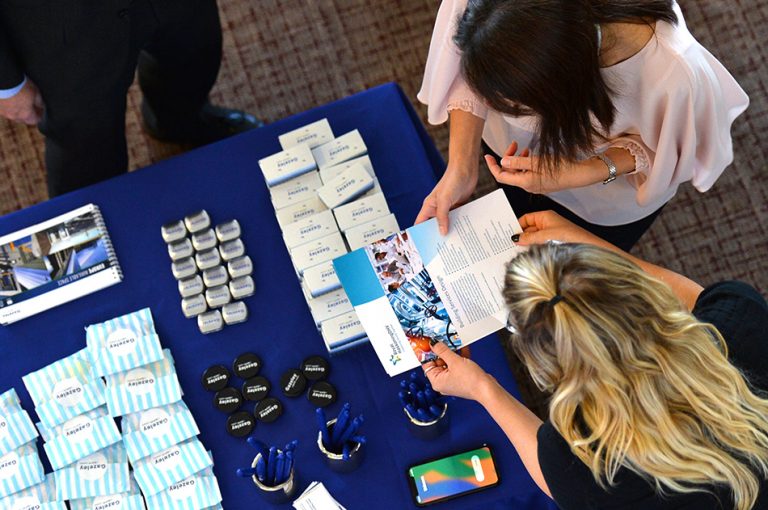 Attendee's converse over a sponsor table at Sheds and Logistics Conference 2019